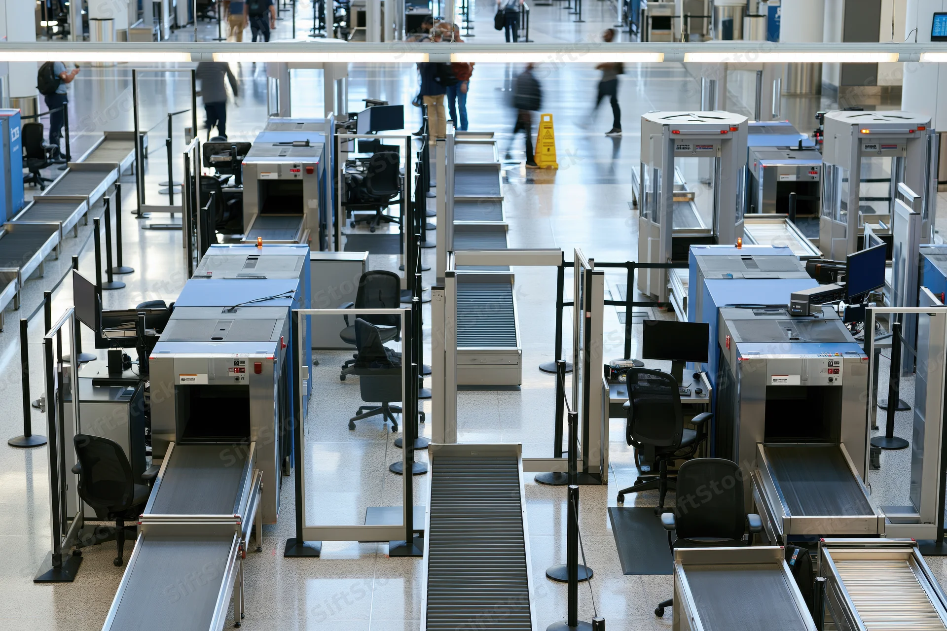 Overhead view of airport security checkpoint with xray scanners and metal detectors arranged in rows
