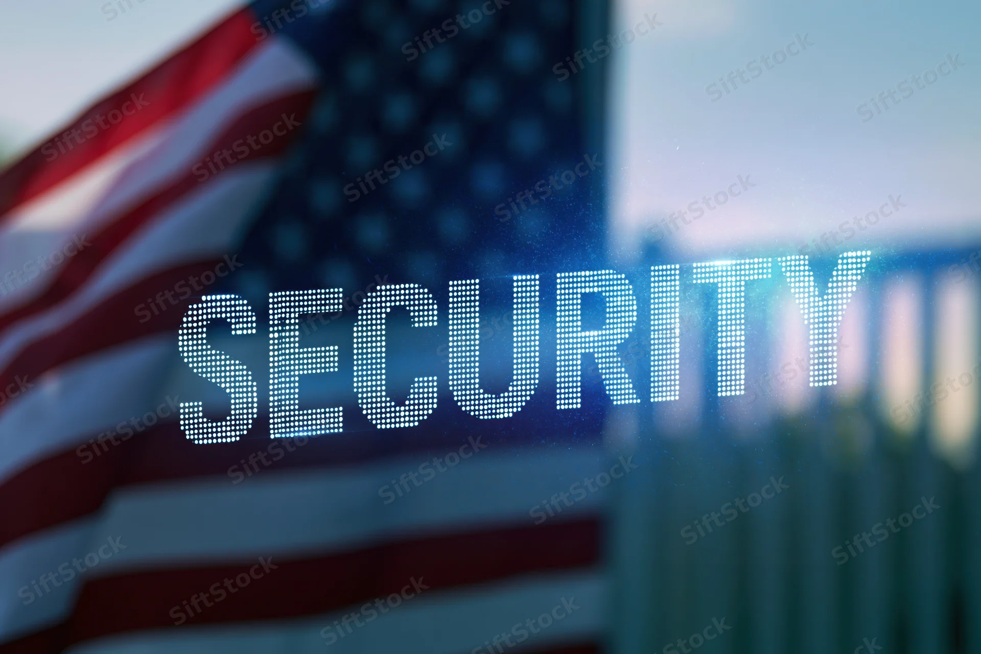 Digital security text overlaid on blurred american flag and fence outdoors