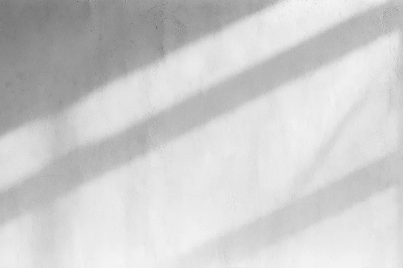 Diagonal light shadows on a bare concrete wall interior