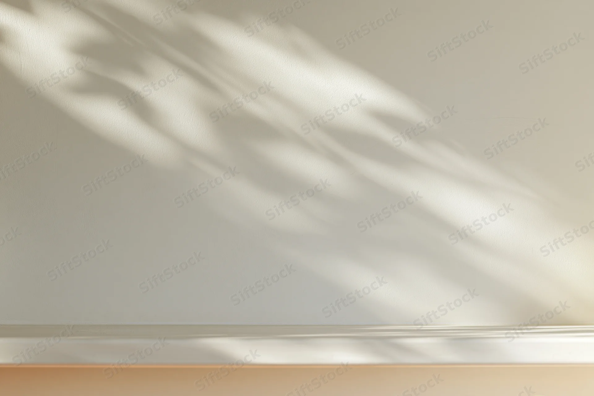 Dappled sunlight shadows from leaves on a smooth cream plaster wall in an empty room