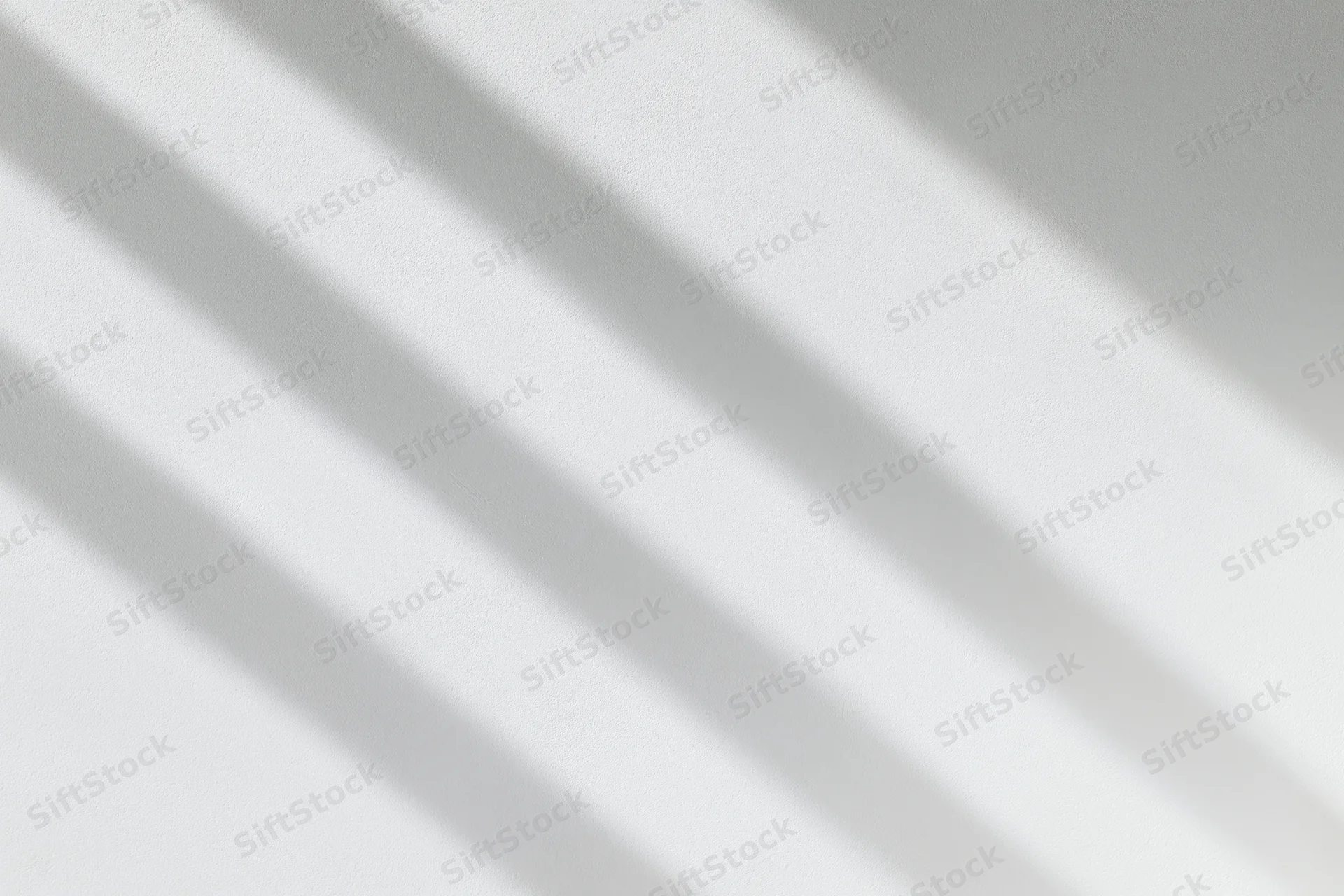 Diagonal shadows on a white plaster wall