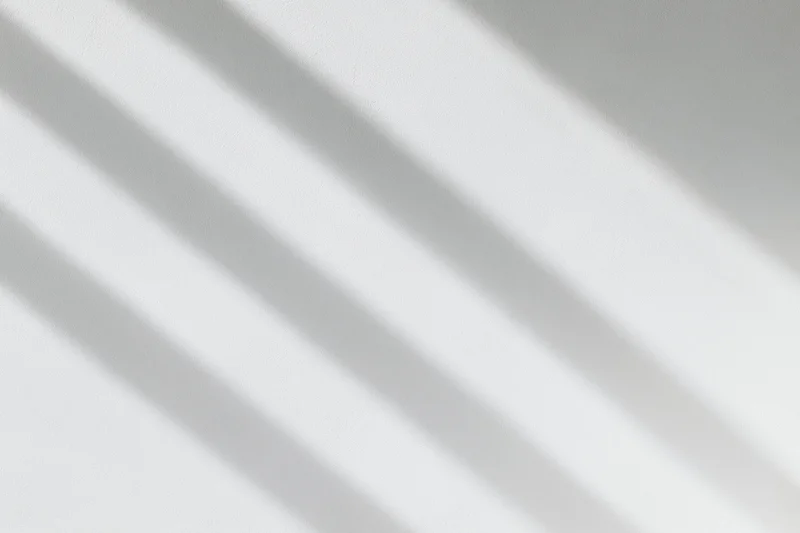 Diagonal shadows on a white plaster wall