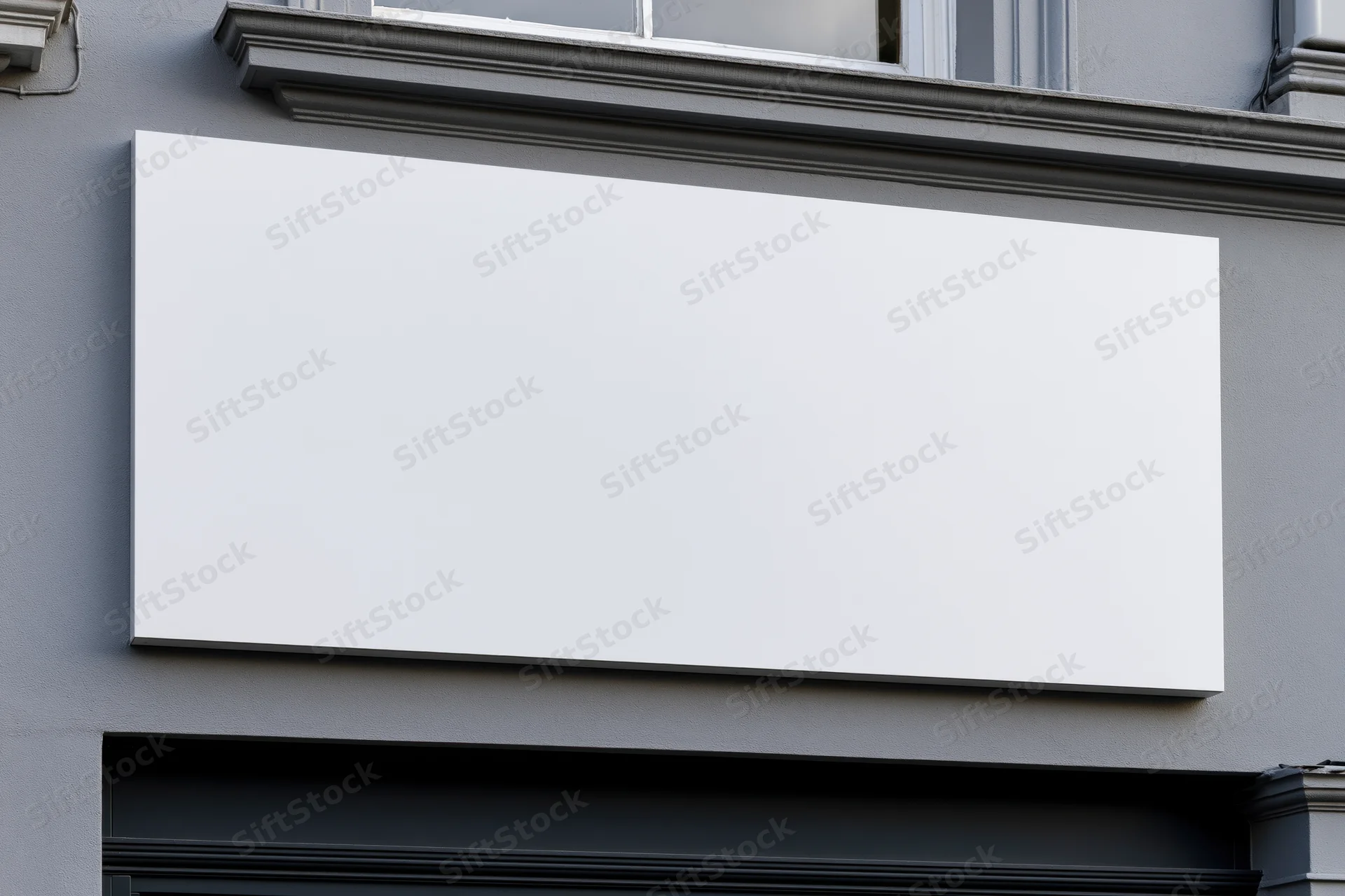 Blank white rectangular sign mounted on gray storefront facade