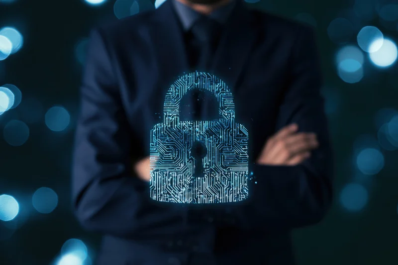 Businessman in dark suit with arms crossed displaying digital circuit lock hologram