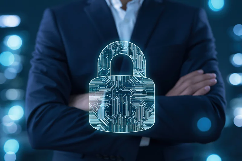 Businessman with arms crossed standing behind a glowing digital lock hologram