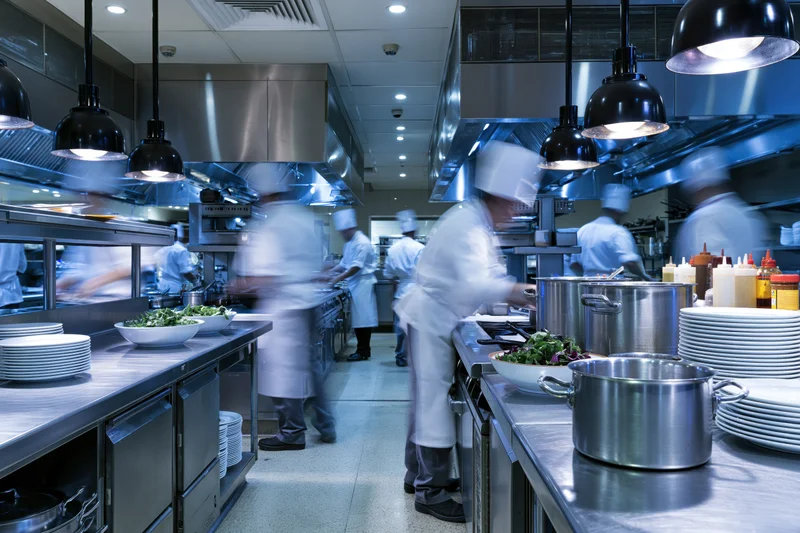 Chefs cooking in a commercial restaurant kitchen during dinner service