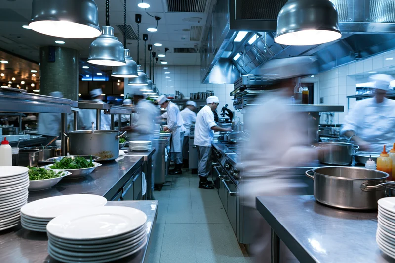 Chefs cooking in a busy commercial kitchen during dinner service