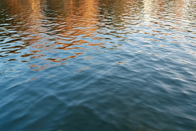 Calm lake surface with gentle ripples reflecting autumn colors