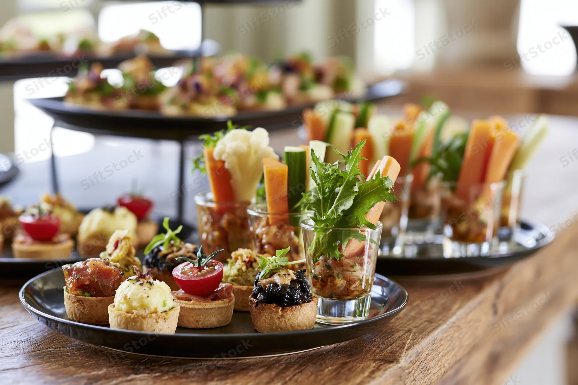 Assorted canapes and vegetable platters arranged on a wooden table for a catering event