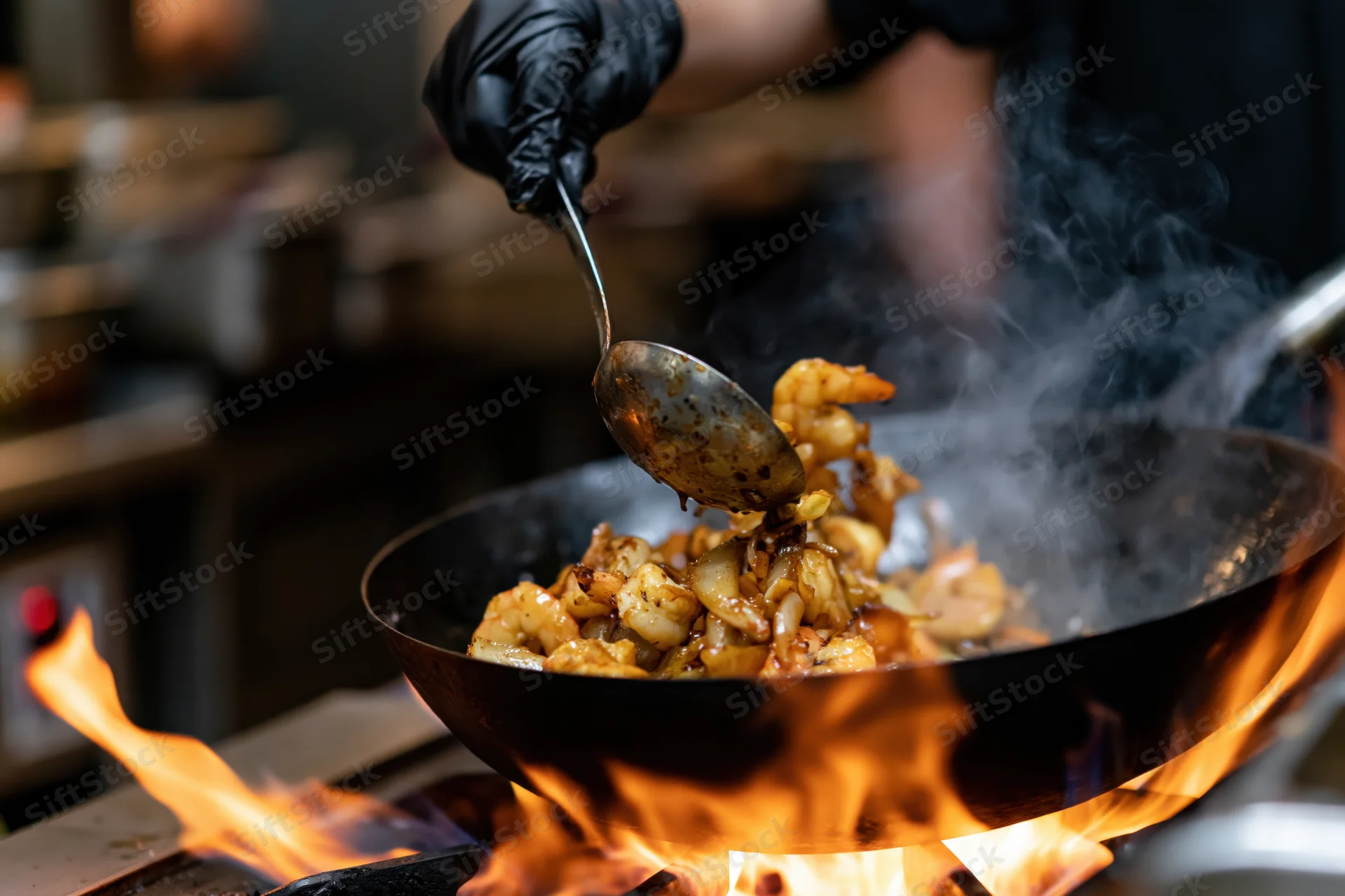 Chef stirring seafood in a flaming wok over high heat in a restaurant kitchen