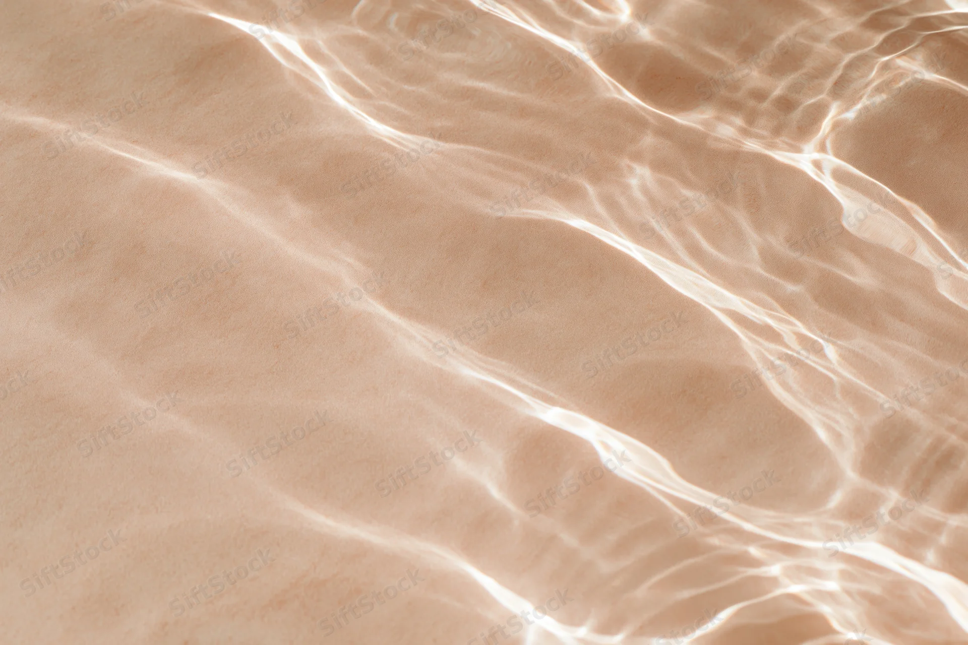 Rippling water surface with light reflections over sandy bottom
