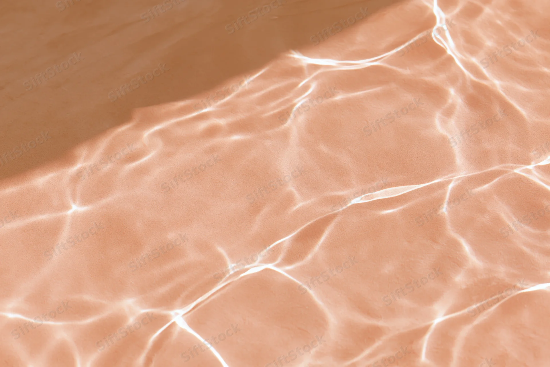 Rippling water surface with light reflections on sandy bottom