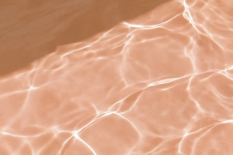 Rippling water surface with light reflections on sandy bottom