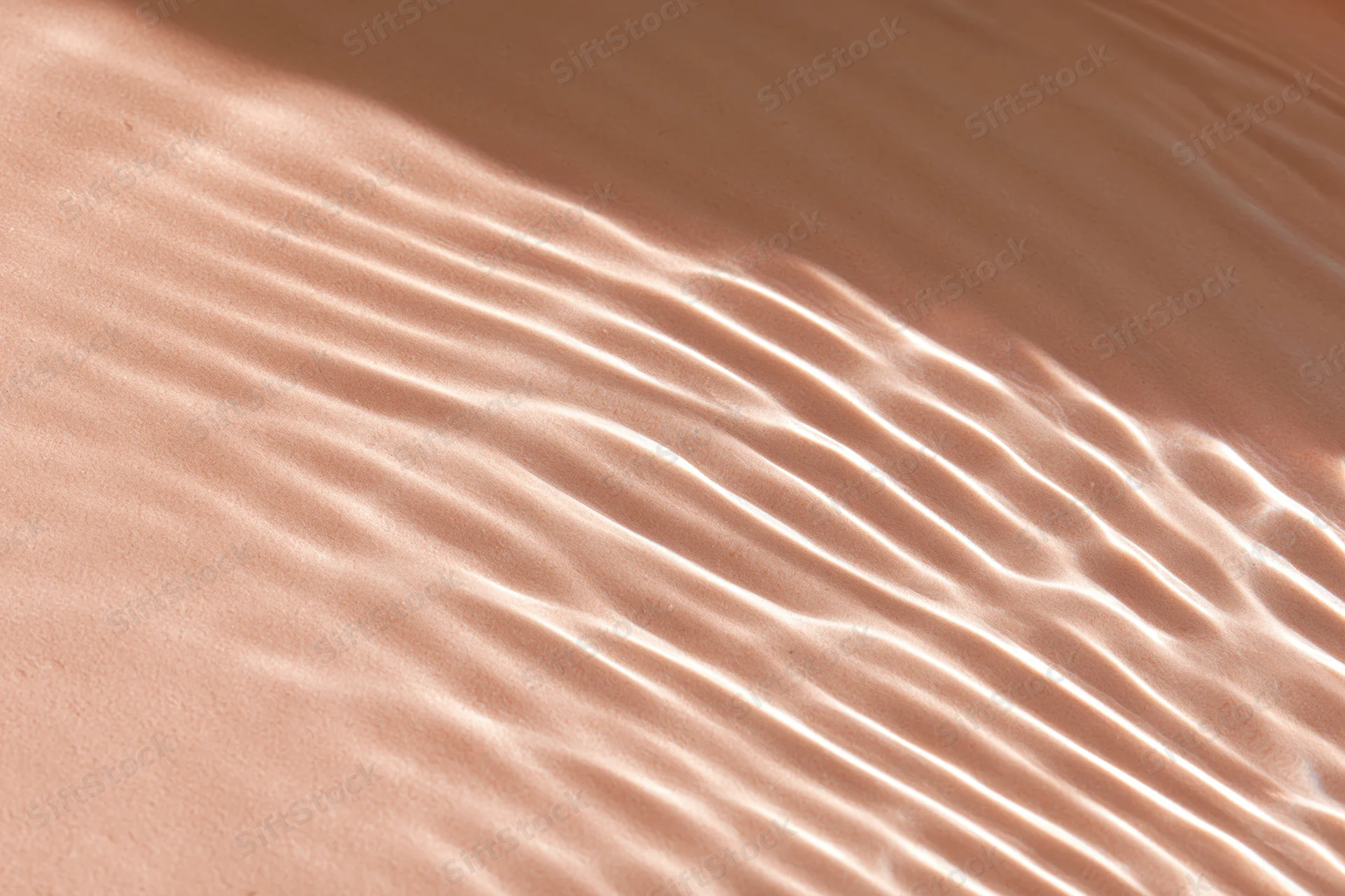 Rippling water surface with light reflections on sandy bottom