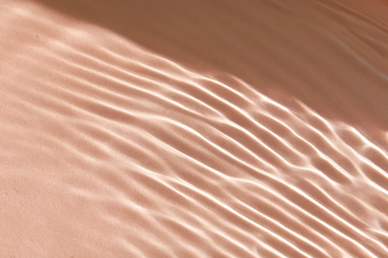 Rippling water surface with light reflections on sandy bottom