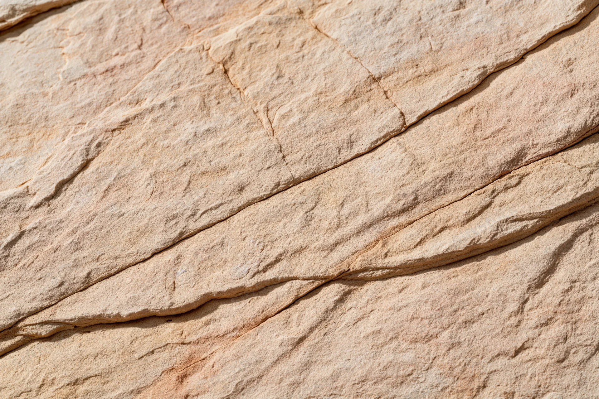 Close-up of layered sandstone rock surface with natural texture and cracks