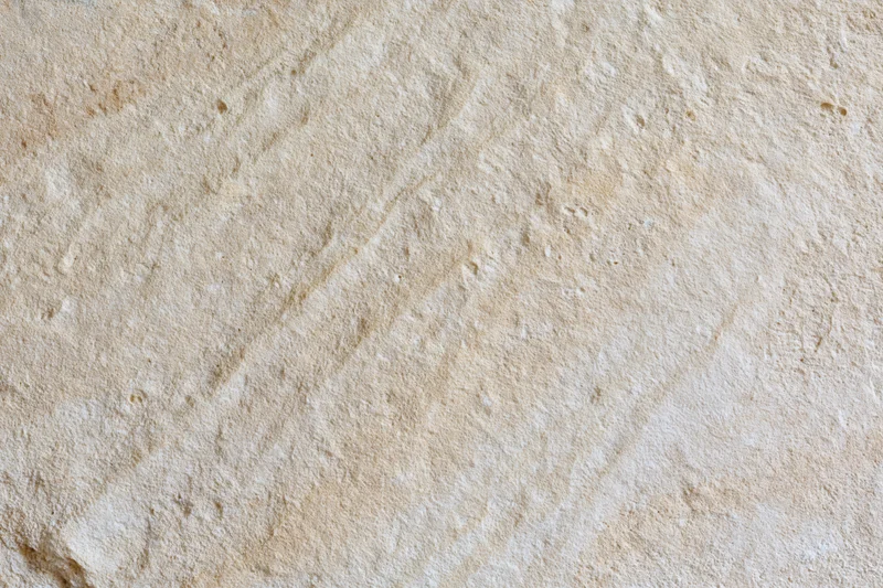 Close-up of rough sandstone surface with natural texture and beige coloration