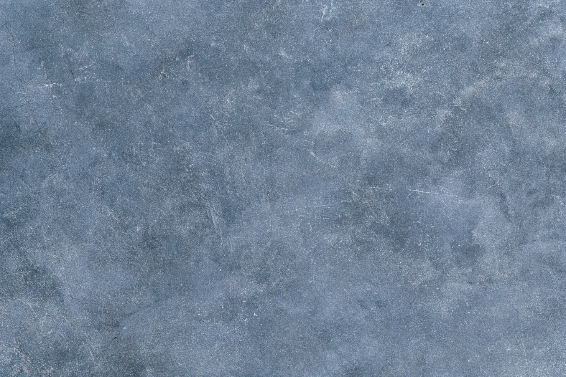 Close-up of a weathered concrete surface with visible scratches and discoloration