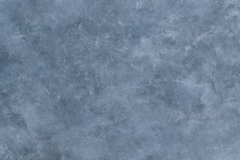 Close-up of a weathered concrete surface with visible scratches and discoloration