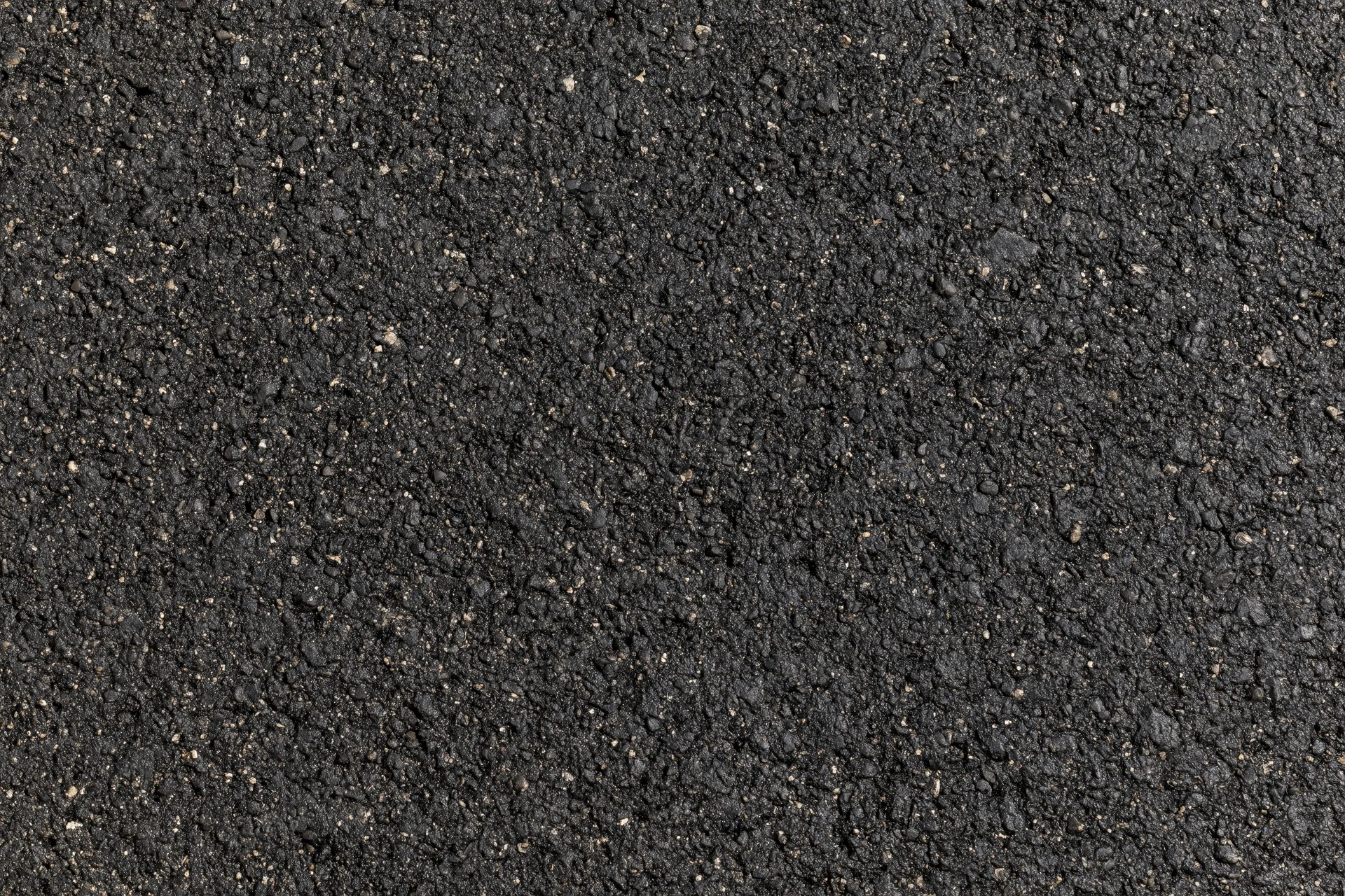 Close-up of dark asphalt pavement surface texture filling the frame