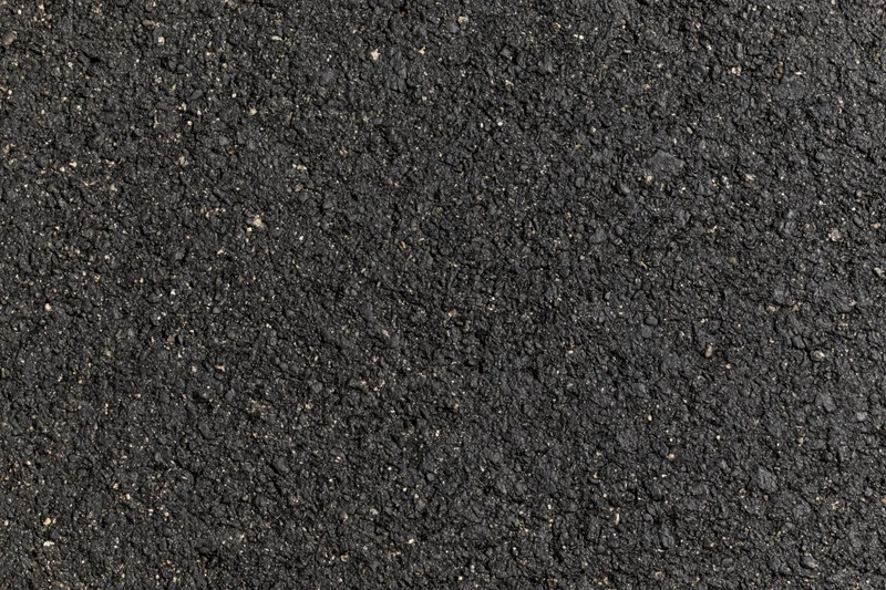Close-up of dark asphalt pavement surface texture filling the frame