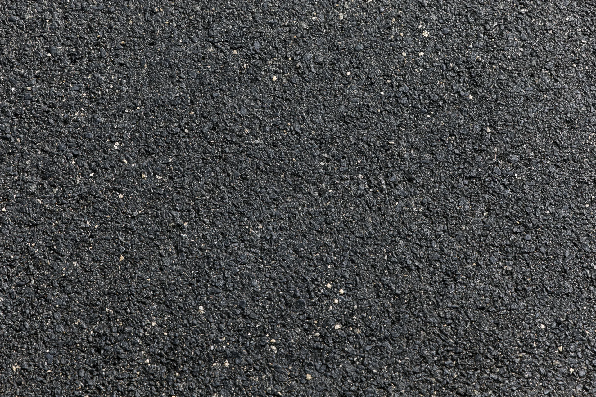 Close-up of dark asphalt pavement surface texture filling the frame