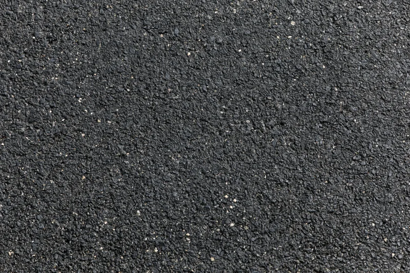 Close-up of dark asphalt pavement surface texture filling the frame