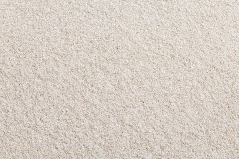 Close-up of fine dry beach sand filling the frame as a textured surface