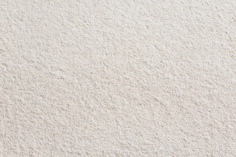 Close-up of fine dry beach sand filling the frame as a textured surface