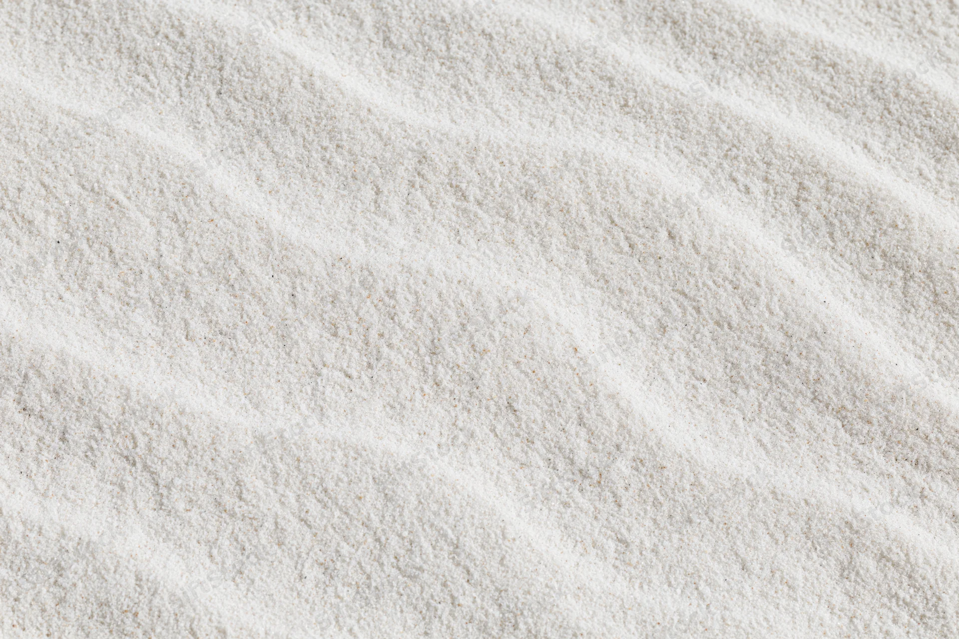 Close-up of fine white beach sand with wind-formed ripples in a flat lay arrangement