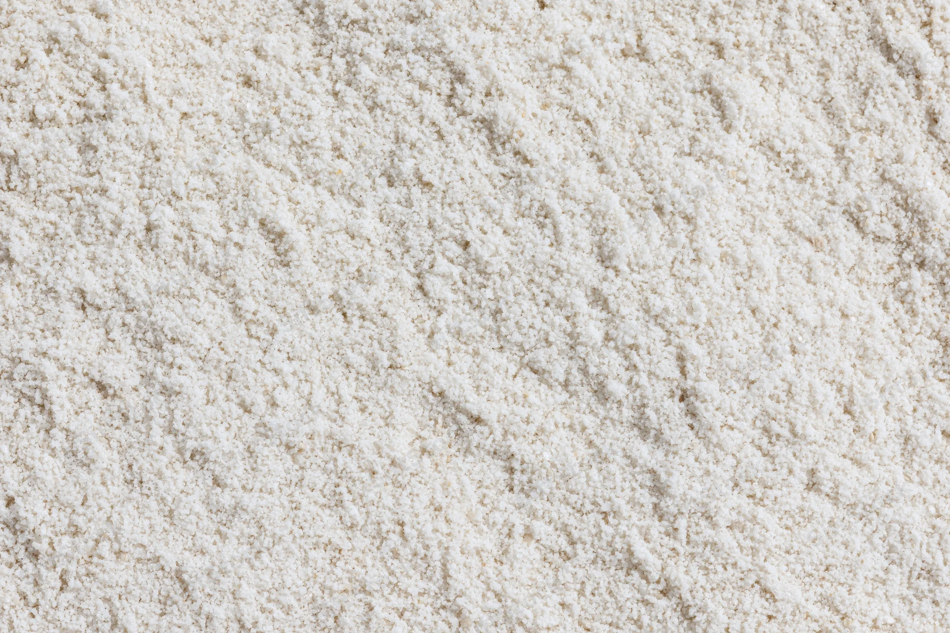 Close-up of fine white sand surface filling the frame