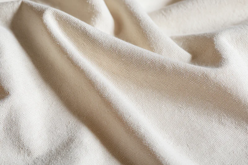 Close-up of natural unbleached cotton canvas fabric laid flat
