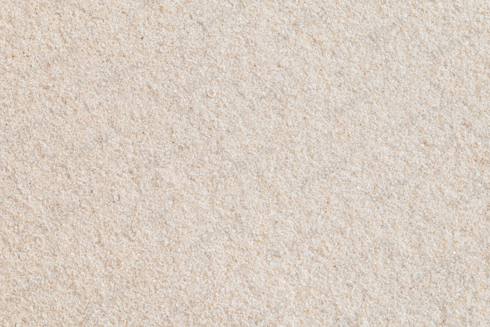 Close-up flat lay of smooth dry beach sand filling the entire frame