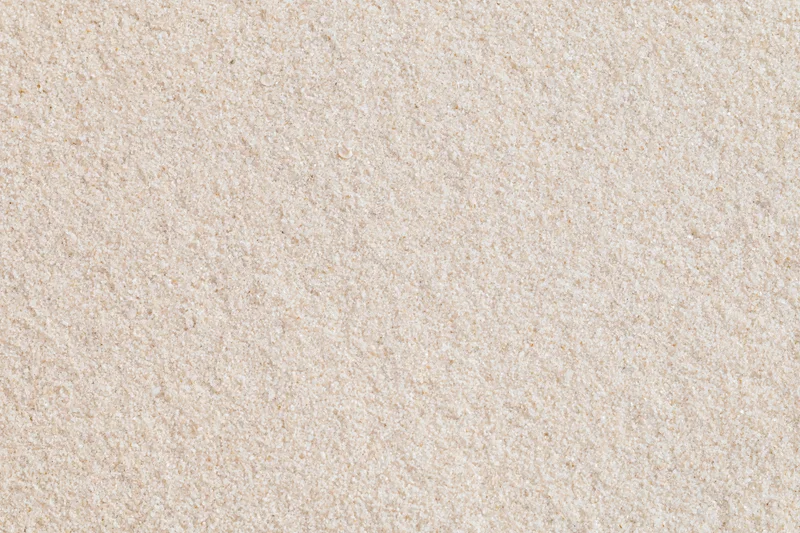 Close-up flat lay of smooth dry beach sand filling the entire frame