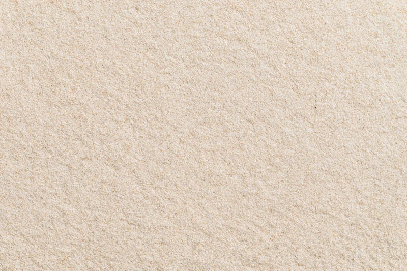 Close-up flat lay of smooth dry beach sand filling the entire frame