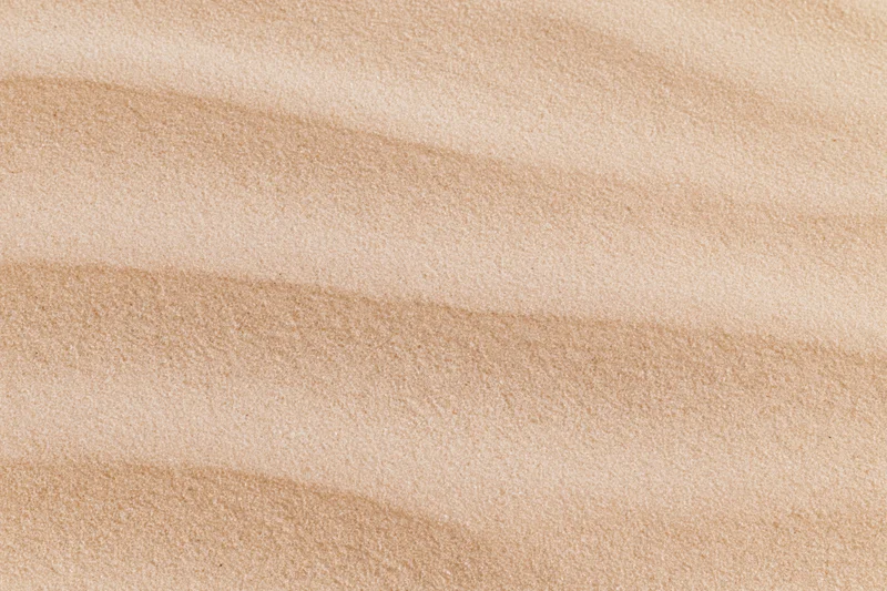 Close-up of smooth dry desert sand surface with rippled texture filling the frame