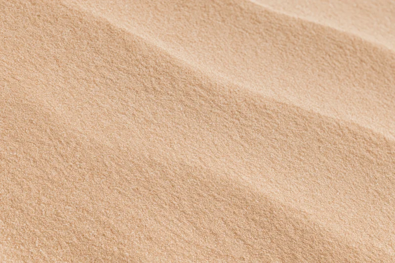 Close-up of smooth dry desert sand surface in flat lay arrangement