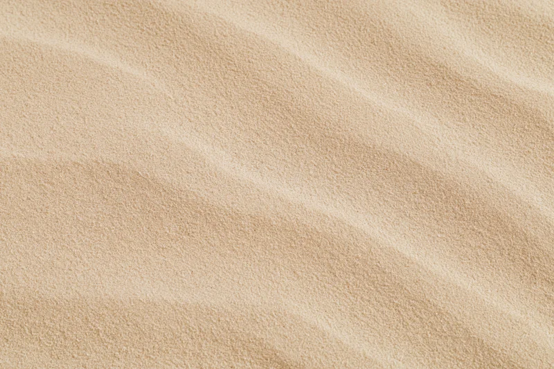 Close-up of smooth dry desert sand surface with rippled texture filling the frame