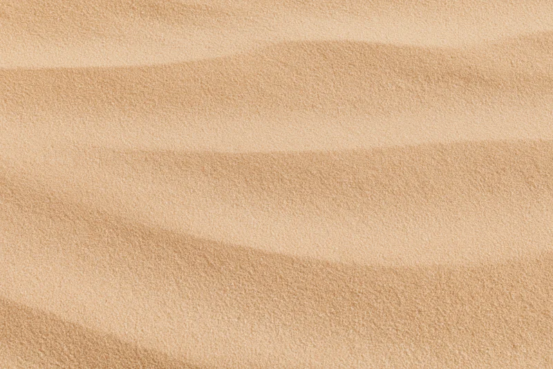 Close-up of smooth dry desert sand surface with rippled texture filling the frame