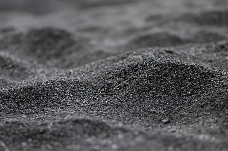 Close-up of black volcanic sand on a beach surface