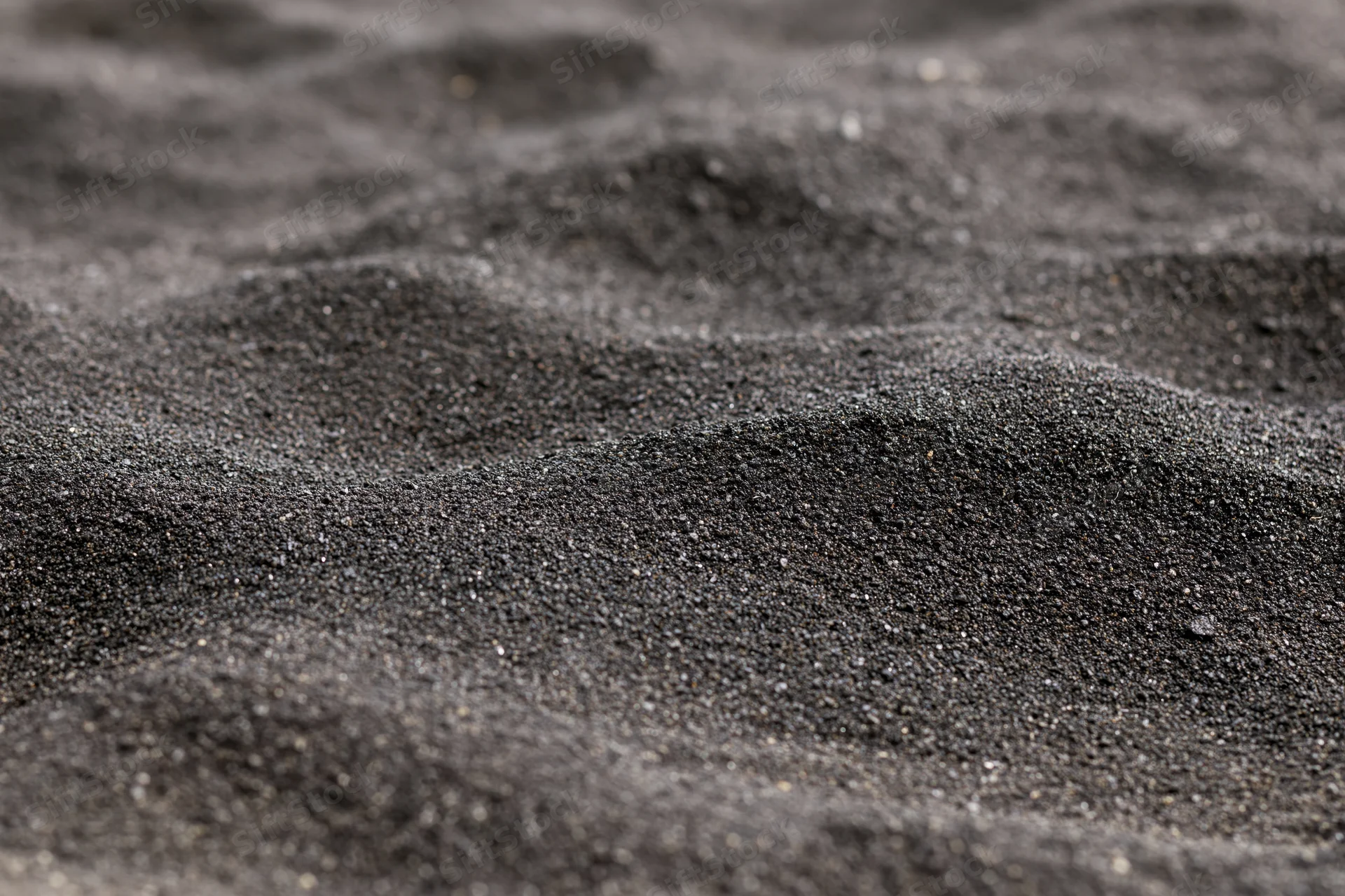Close-up of black volcanic sand on a beach surface