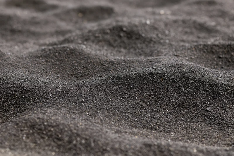 Close-up of black volcanic sand on a beach surface