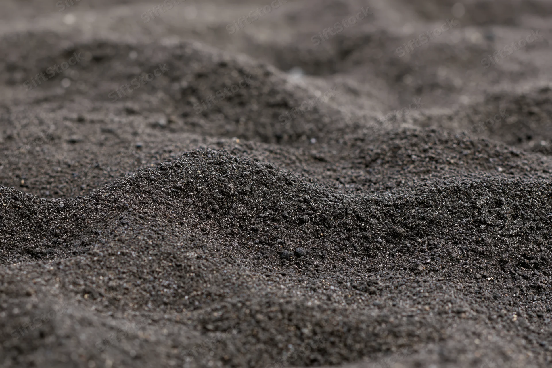 Close-up of black volcanic sand on a beach surface