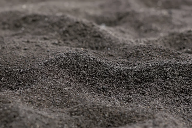 Close-up of black volcanic sand on a beach surface