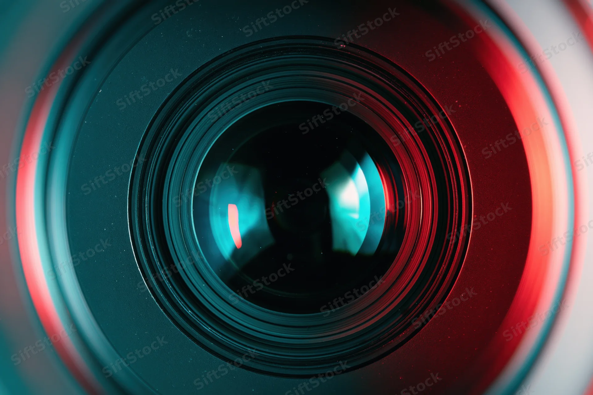 Close-up of a camera lens front element with red and blue light reflections