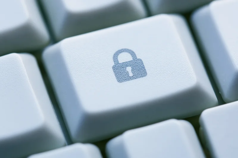 Close-up of a white keyboard key with a lock symbol indicating digital security