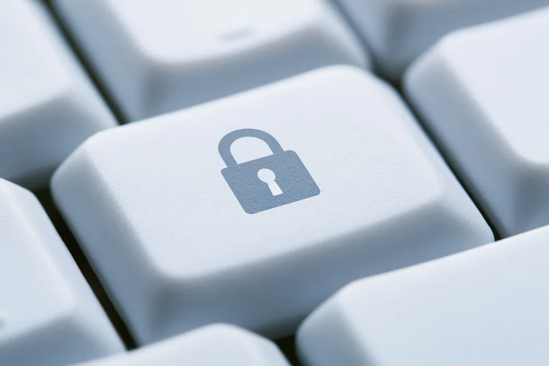 Close-up of a white keyboard key with a lock symbol indicating digital security