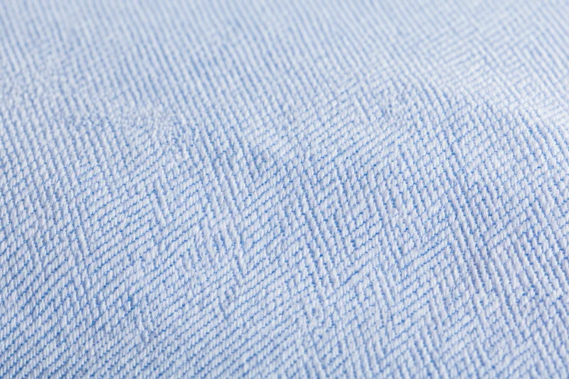 Close-up of light blue and white woven fabric texture from a dress shirt