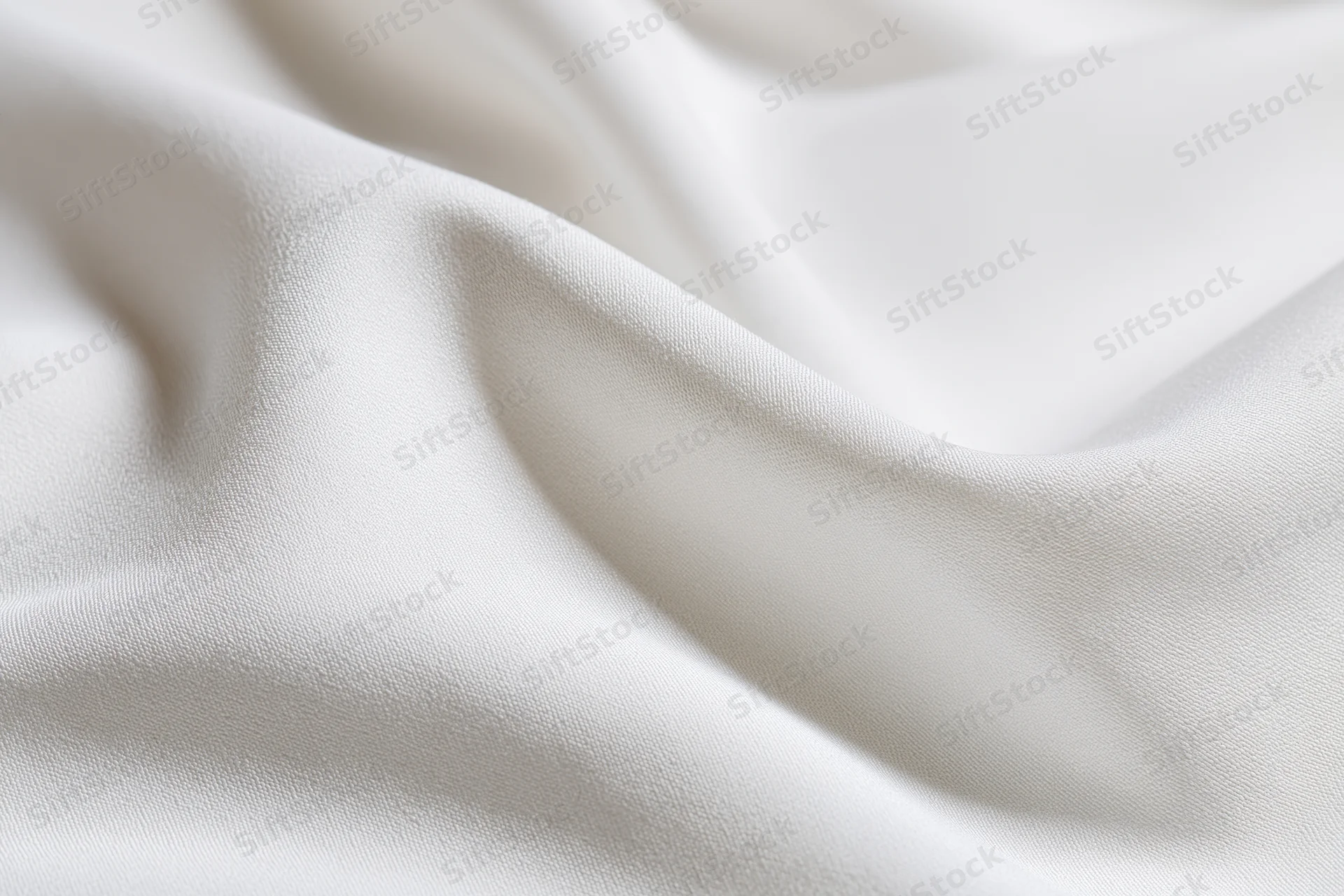 Close-up of white fabric with soft diagonal folds and gentle undulations