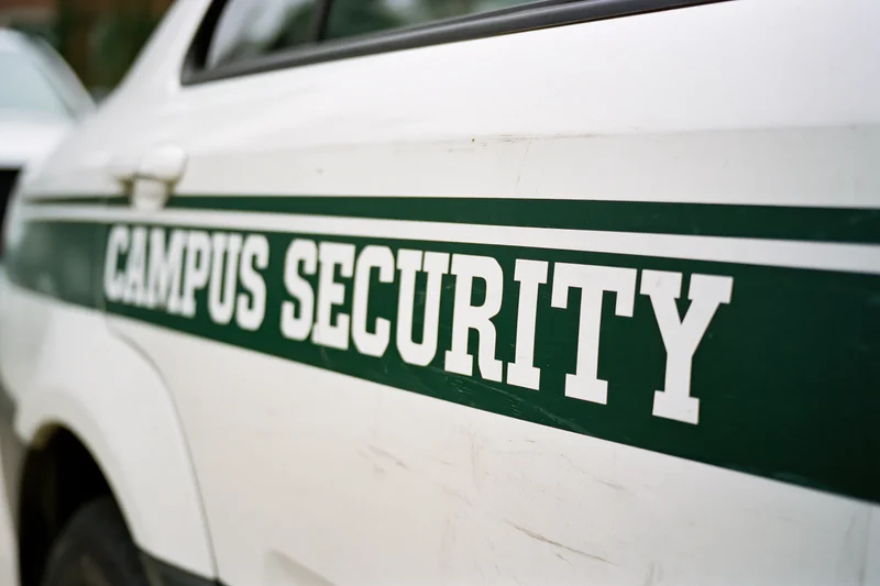 Close-up of white campus security vehicle door panel with green lettering